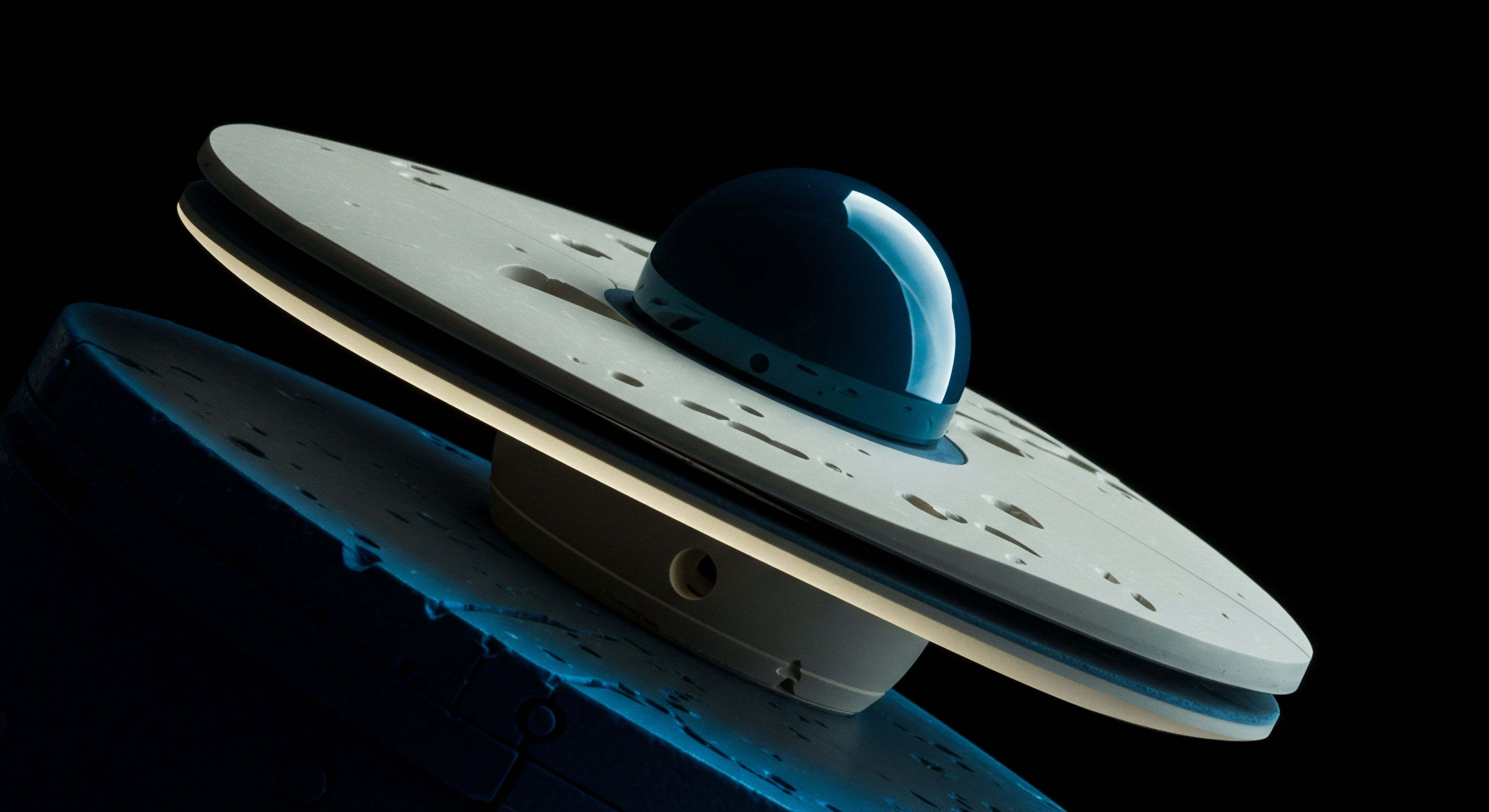 This abstract macro photograph depicts a sleek, dual-layered disc structure reminiscent of a Flying Saucer or a Saturnian ring system, featuring a dark, highly reflective, smooth dome atop a pale, pockmarked upper plate. The composition, set against an absolute black background, suggests an isolated, engineered environment, perhaps modeling the geometry of decentralized finance governance frameworks or exotic derivatives structures. The luminescence emanating between the layers evokes instantaneous settlement or high-velocity liquidity deployment, mirroring rapid execution of complex perpetual futures strategies or cross-chain atomic swaps. The lower structure exhibits a rougher, textured surface bathed in cool cyan light, symbolizing underlying, volatile blockchain infrastructure or collateralized debt positions being rehypothecated across DeFi protocols, illustrating latency arbitrage opportunities in non-custodial yield farming mechanisms.