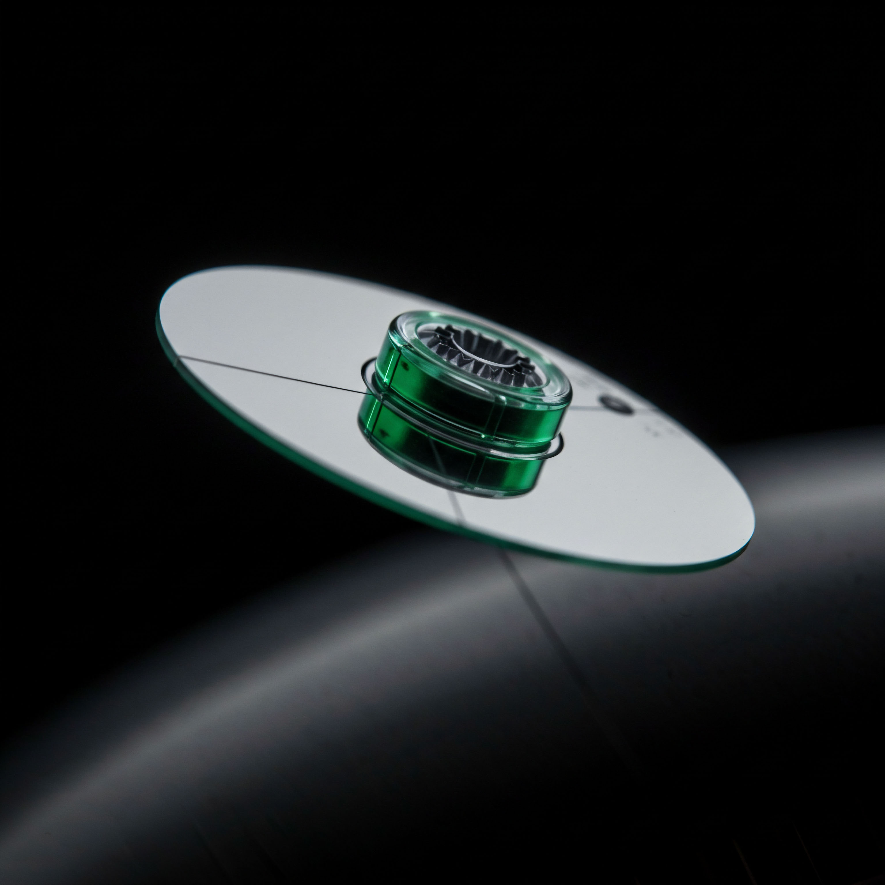 A highly reflective, subtly green-edged toroidal object centers atop a planar disc reminiscent of a cryptographic ledger surface, suggestive of leveraged decentralized finance mechanisms. This composition visualizes the complex interplay between hard assets and synthetic exposure within digital asset markets. The central green element symbolizes staked collateral or a locked perpetual futures contract underpinning a volatile spot trade. The thin, almost invisible tethers traversing the reflective plane evoke low-latency execution paths essential for high-frequency algorithmic arbitrage in decentralized exchanges. This metaphorically represents the delicate balance of margin requirements and potential liquidation cascades inherent in tokenized derivatives trading structures, emphasizing capital efficiency and security protocols like zero-knowledge proofs securing off-chain settlement layers.