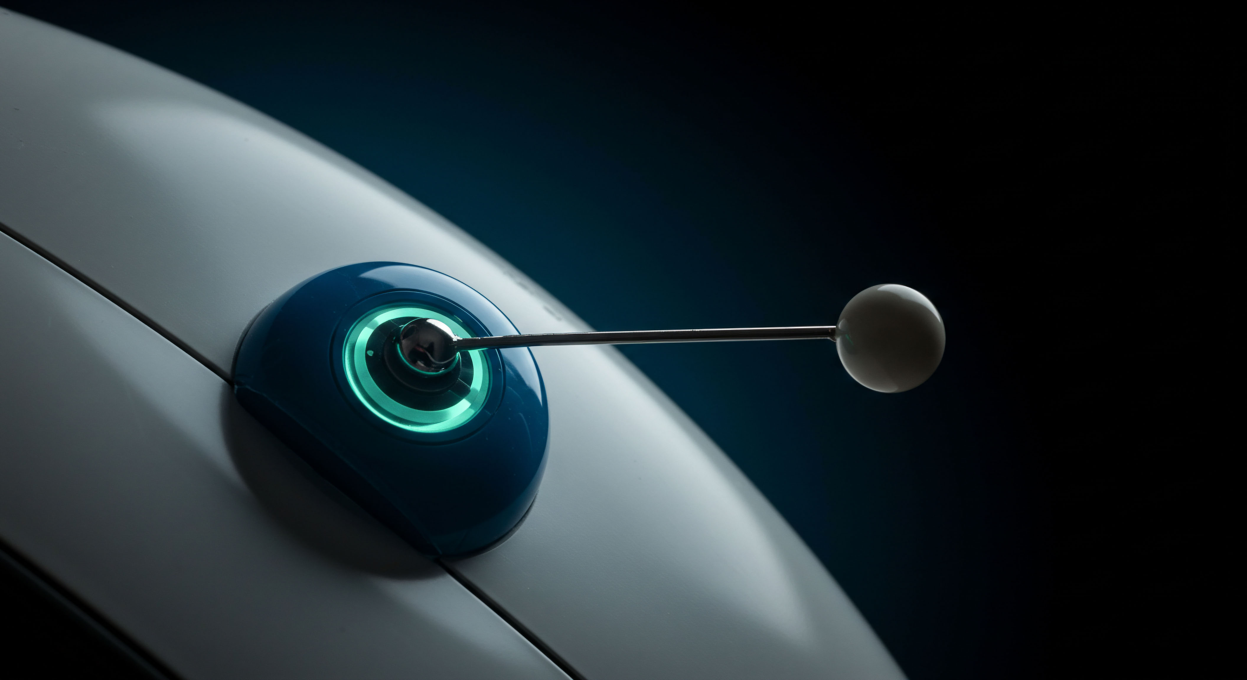 A macro shot captures a sleek, dark blue housing emitting a vivid cyan luminescence surrounding a central metallic pivot point. A thin armature extends outward, culminating in a muted spherical sensor ball against a deep, near-absolute black background suggesting a vacuum or deep digital space. This visually represents the precise execution of on-chain governance proposals or the delicate calibration of complex volatility surfaces. The glowing element evokes the real-time settlement ledger of decentralized finance DeFi protocols. Specific nodes of high-frequency trading HFT algorithms are simulated by this probe interacting with a structured asset base layer, perhaps indicating gamma scalping maneuvers within perpetual futures markets or the sensitive adjustment of implied volatility inputs for bespoke synthetic asset contracts, far removed from simple spot price action.