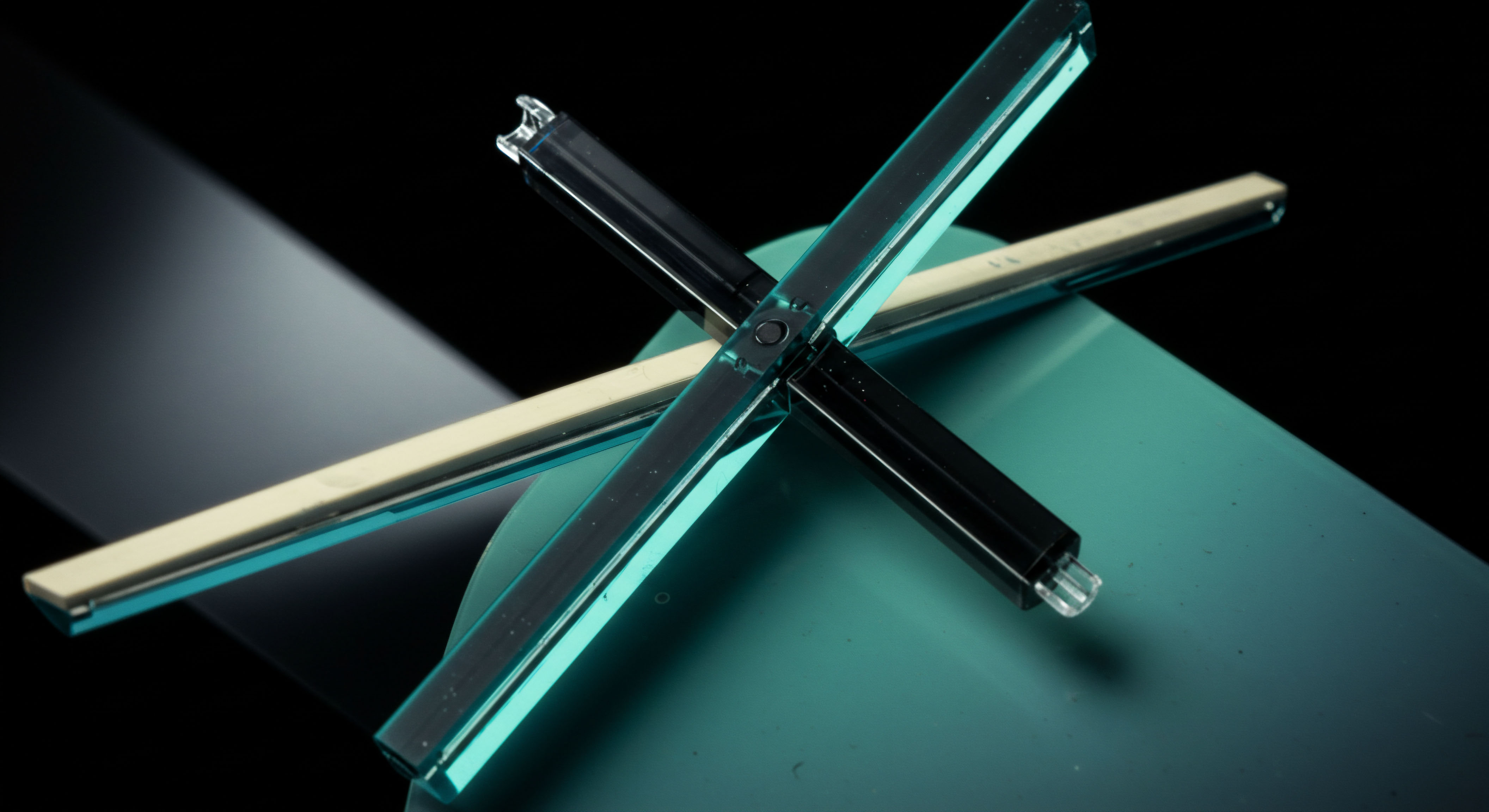 The composition features two intersecting, angular polymeric structures exhibiting cyan luminescence, overlaid upon a matte teal substrate, suggesting engineered financial architecture. This configuration metaphorically represents the convergence of cross-margined collateral chains or the intrinsic geometry of options straddles executed via decentralized finance protocols. One element, pale beige, contrasts the dominant crystalline components symbolizing underlying token assets or stablecoin collateralization requirements. The intersection point signifies a nexus, perhaps a smart contract escrow or an executed perpetual futures contract settlement. This visual tension embodies non-linear payoff profiles inherent in complex derivatives pricing models and decentralized clearing mechanisms within the volatile digital asset landscape, emphasizing capital efficiency and counterparty risk mitigation strategies like layered vesting schedules.