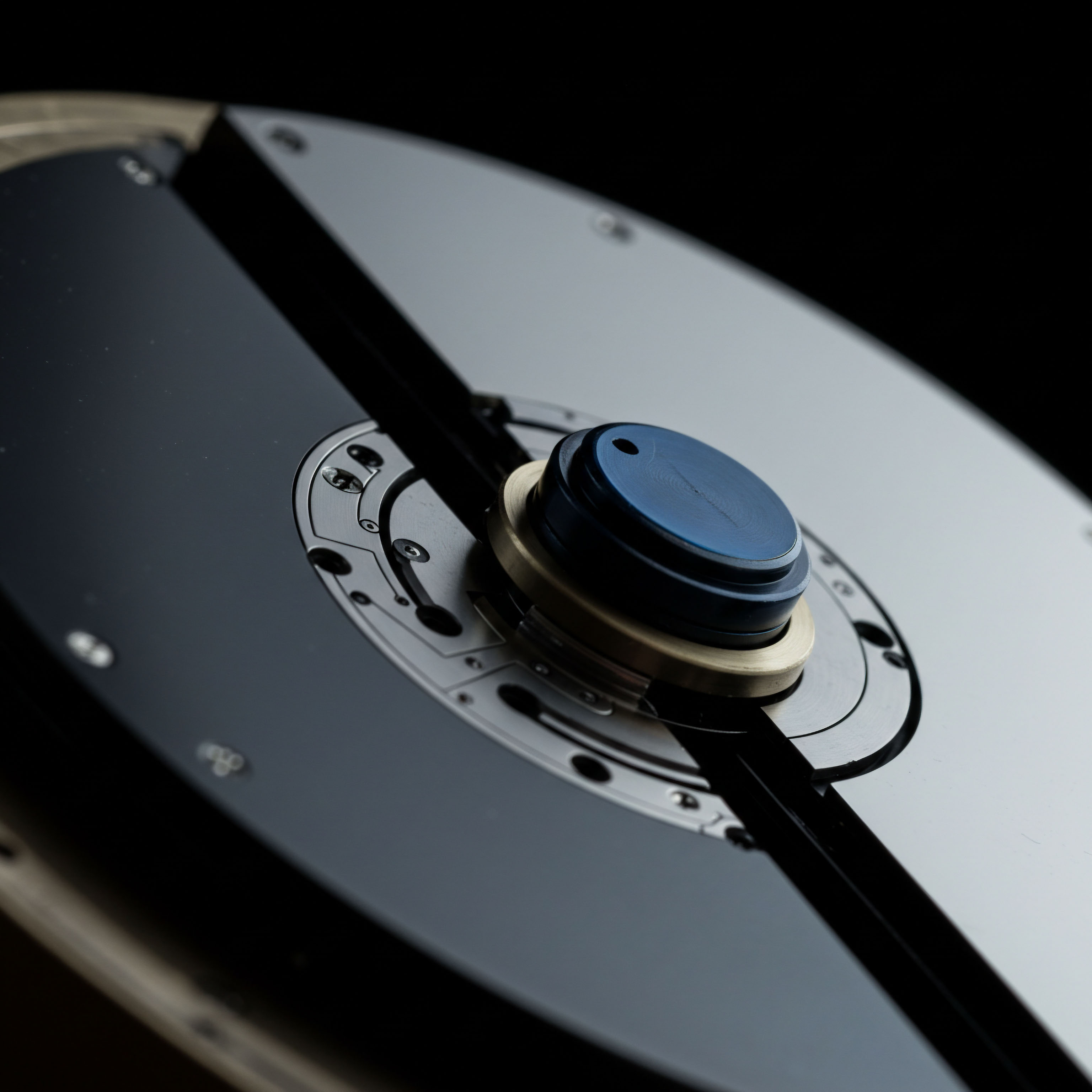 This abstract, macro depiction showcases a juxtaposition of highly polished surfaces bisected by a dark, definitive line, suggesting instantaneous contract execution or a hard fork event. The central hub features layered components a blue cap atop brass ring hardware over intricate, machined metallic plating reminiscent of complex algorithmic trading infrastructure or perhaps an escrow collateral mechanism. The visual dichotomy reflects the bifurcated state of asset settlement or the risk/reward profile inherent in leveraged futures contracts. Deep focus highlights the precise engineering necessary for resilient on-chain governance and high-frequency liquidity provisioning within decentralized exchange environments, modeling concepts like oracle data feeds interacting with smart contract logic for options payoff determination, emphasizing minimized slippage across volatile crypto asset pairings.