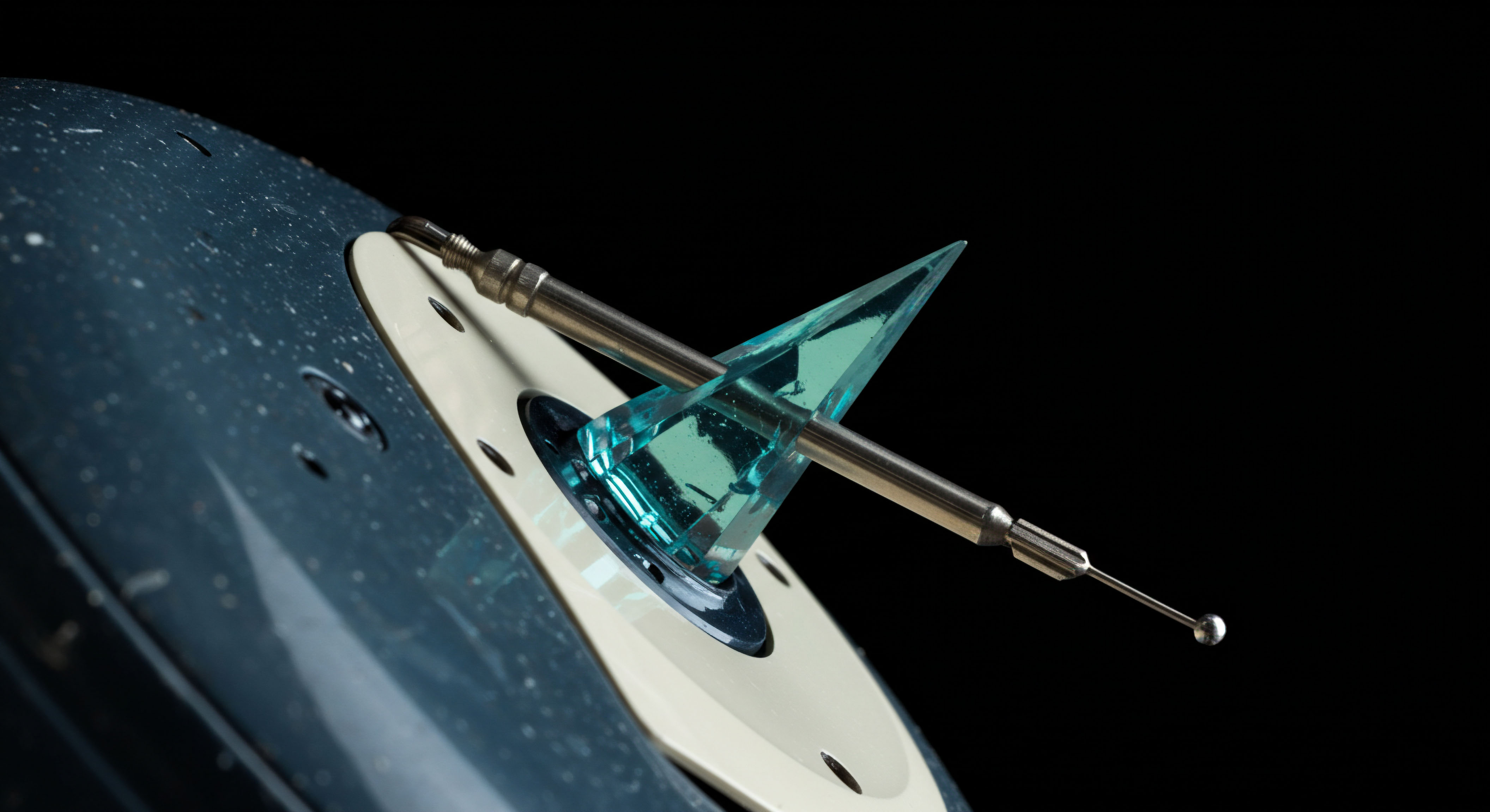 This macro photograph captures a highly polished metallic stylus terminating in a spherical probe interacting with a translucent cyan crystalline geometric prism mounted on a speckled dark blue substrate, suggestive of advanced financial instrument calibration. The sharp angularity of the crystal evokes algorithmic strategies for managing basis risk in perpetual futures contracts, especially during extreme market asymmetry. The robust stylus represents the precise measurement required for effective collateral management and calculating the intrinsic value decay of exotic options structures. This visual metaphor symbolizes the meticulous algorithmic reconciliation inherent in decentralized autonomous organization governance mechanisms concerning structured products and counterparty default swaps across volatile DeFi landscapes. The focused illumination highlights the sharp edge interface, mirroring the delicate execution of delta hedging in high-frequency trading environments.
