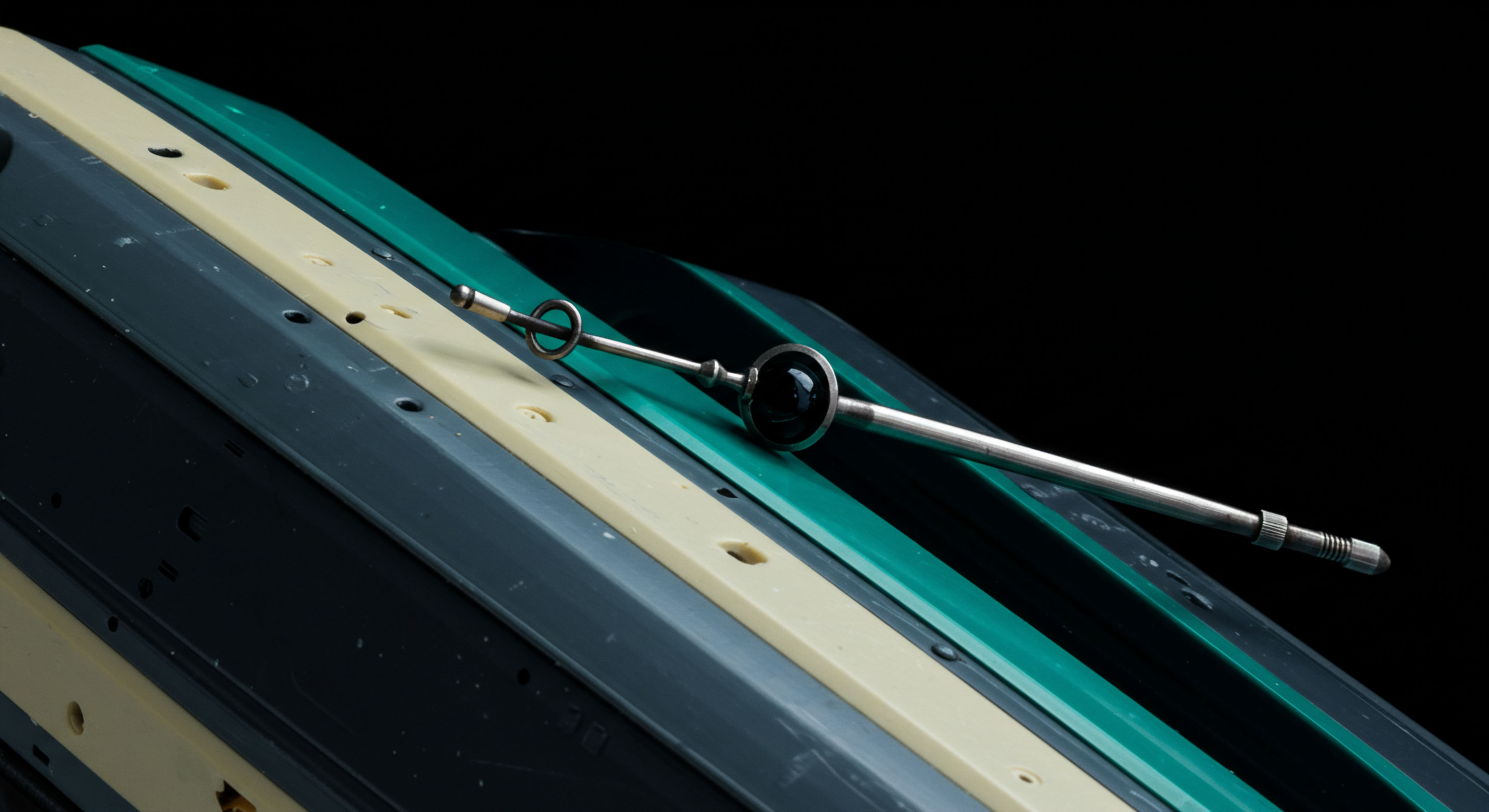 This intricate metallic calibration tool rests diagonally across layered substrates featuring cyan teal, pale ivory, and slate dark gray planes suggesting tiered collateralization or ledger strata. The polished rod, featuring knurled termini and a prominent obsidian spherical node, symbolizes an active pricing oracle feeding real time market data into decentralized finance protocols. This apparatus metaphorically represents the rigorous verification required for establishing accurate strike prices or margin maintenance calls within complex automated market maker structures. Key concepts illuminated include over collateralization ratios smart contract execution integrity and the critical path analysis for achieving true settlement finality across cross chain asset transfers. It underscores the necessity of tamperproof data streams for robust decentralized derivatives markets.