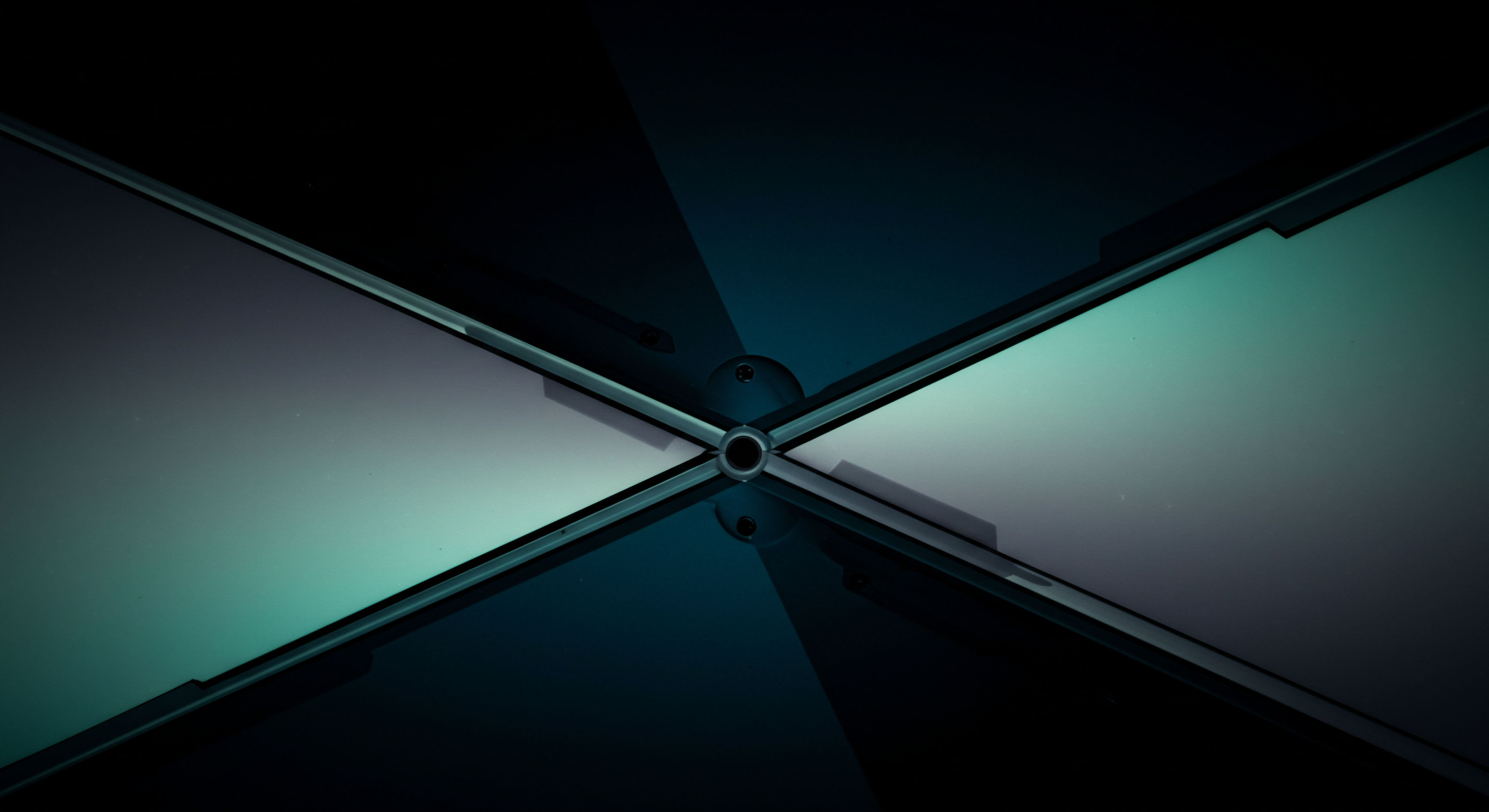 This stark visual depicts four illuminated panels converging at a central nexus, strongly suggesting a system architecture analogous to high-frequency market microstructure. The opposing light gradients imply divergent asset flows or volatile contract states across a cross-exchange interface. It mirrors the structural complexity of synthetic asset creation requiring multi-lateral collateralization mechanisms. The central pivot symbolizes the atomic transaction clearing point, crucial for minimizing slippage in cross-chain atomic swaps or resolving perpetual futures open interest. Keywords like delta hedging, synthetic yield farming, order book depth asymmetry, automated market maker invariant violation, and fractional reserve digital asset structuring are evoked by this bipartite graphical tension.