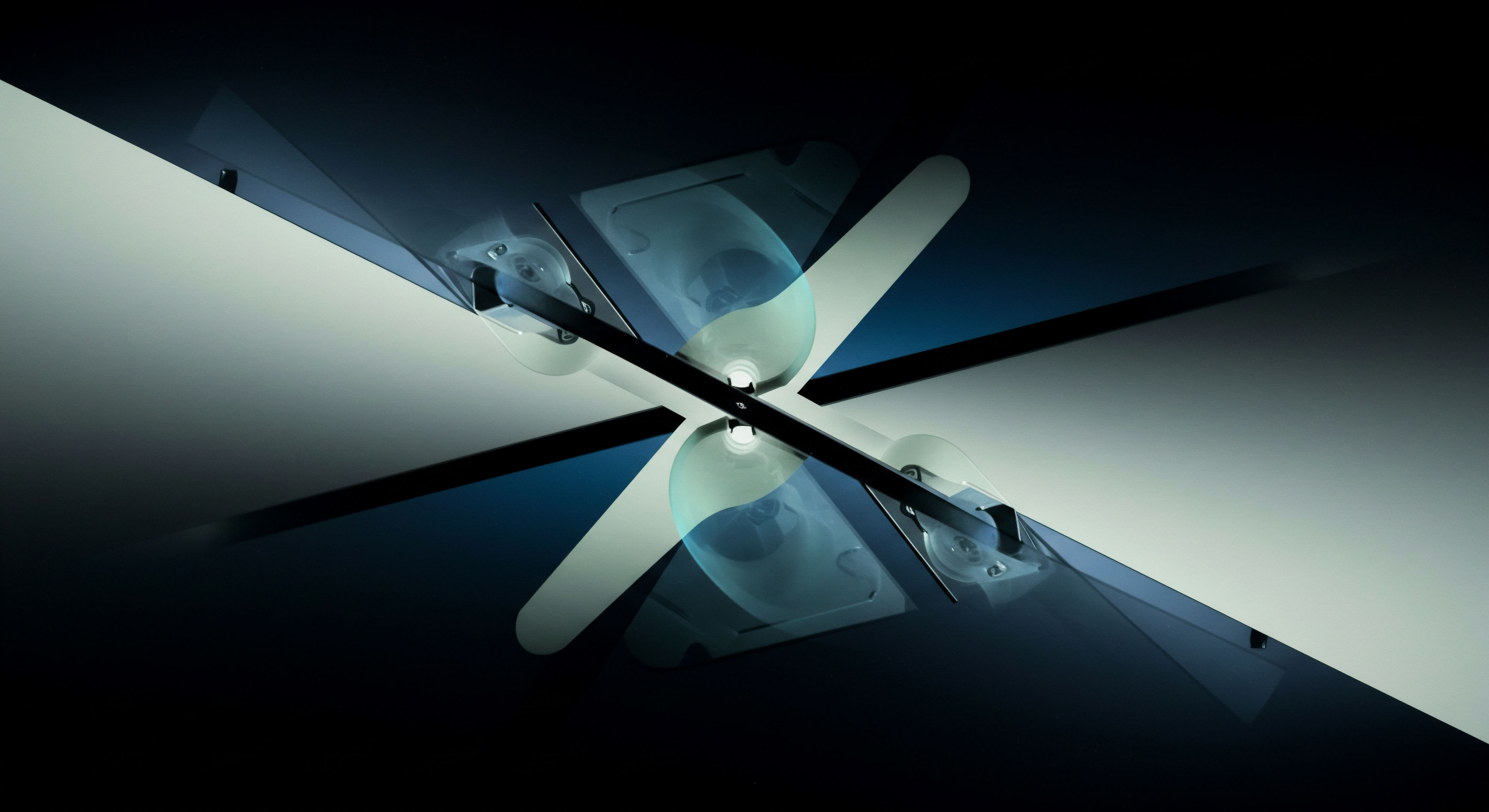 This abstract rendering displays a symmetrical, intersecting structure against a dark, deep blue gradient background suggesting high-frequency market depth. Two bright, opposing light beams emanate diagonally, bisected by a central dark axis where translucent, almost spectral cyan shapes overlay the intersection point, resembling mirrored parabolic curves or potential functions. This visual metaphor captures the complex interplay of order flow and latent market structure inherent in decentralized finance derivatives. The configuration strongly evokes the mathematical representation of option Greeks such as delta hedging requirements or the skew induced by directional bias in perpetual swaps. Specifically, the overlapping translucent elements suggest interwoven synthetic positions, perhaps mirroring the construction of complex payoff diagrams like butterfly spreads or calendar spreads on decentralized exchanges DEXs, demanding precise computation of slippage and liquidity provider LP exposure in low-latency cryptocurrency markets. This visualization underscores systemic risk aggregation within digital asset options vaults.