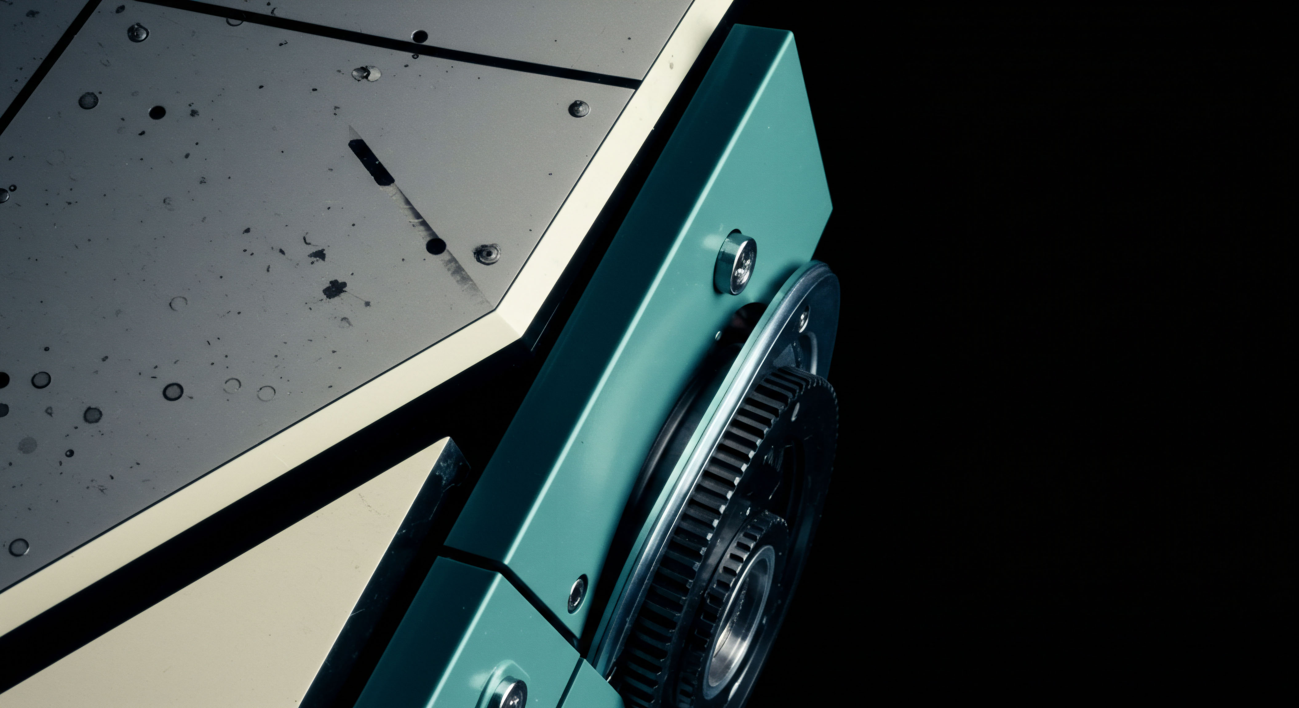 This stark macro shot depicts the interface between a smooth teal metallic housing and a distressed, off-white panel exhibiting microscopic impact craters suggestive of historical data residue or failed order executions. A visible, precision-engineered black toothed gear assembly hints at intricate mechanical execution mechanisms foundational to modern decentralized autonomous organizations governance or automated market maker quoting engines. The dark void background emphasizes the isolation of this component, symbolizing the opaque counterparty risk within leveraged derivatives collateral management. It evokes the intricate, sometimes unforgiving mechanics underlying perpetual swaps settlement and volatility surface calibration on nascent decentralized exchanges demanding absolute system integrity against malicious atomic swaps or flash loan exploits.